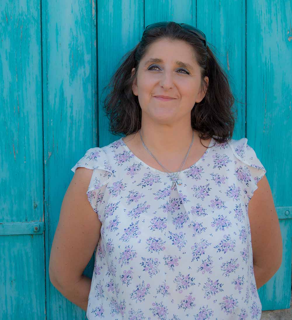 Femme devant un mur turquoise.