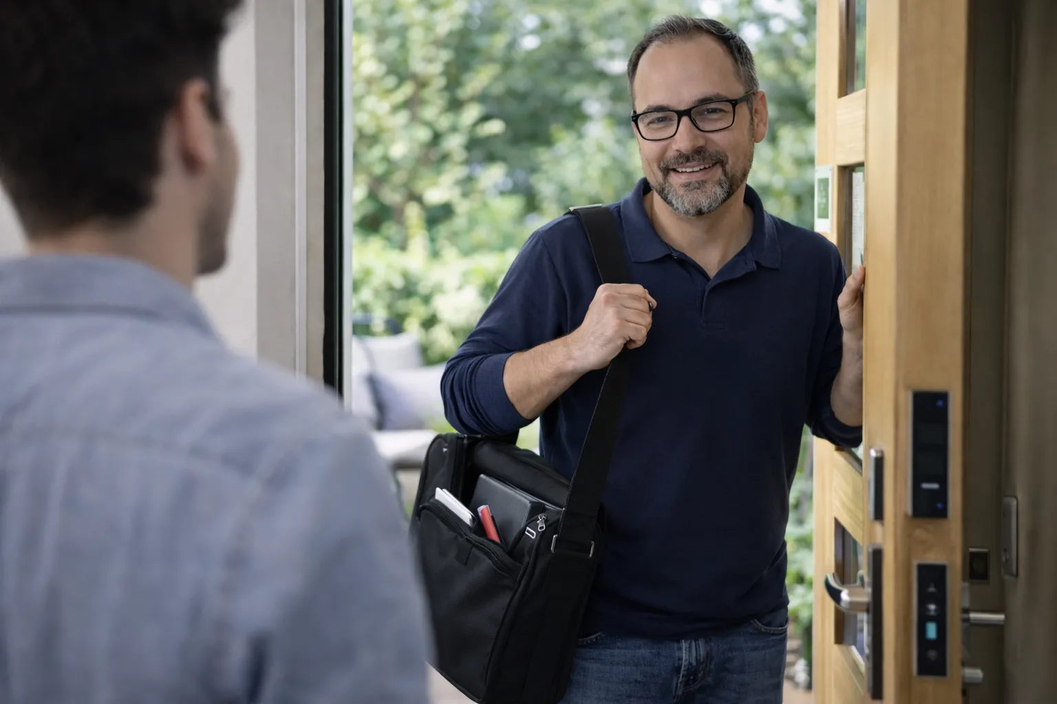 Homme souriant à la porte d'entrée.